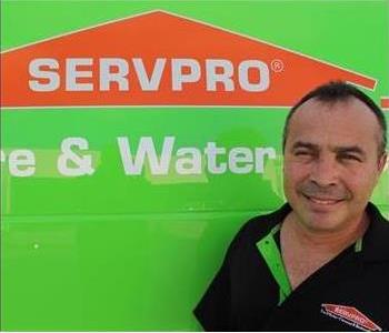 Crew Chief with black shirt and  servpro logo near green truck
