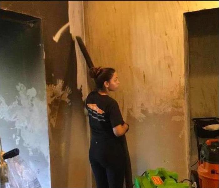 woman removing soot damage in a building